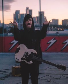 a man with his hands in the air while holding an electric guitar