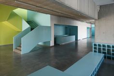 an empty room with blue and green walls, stairs and shelves on the floor in front of it