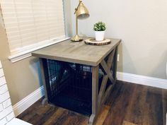 a dog crate with a potted plant on top in the corner of a room