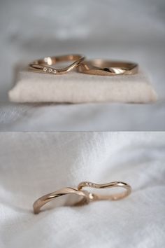 two wedding rings sitting on top of a white cloth