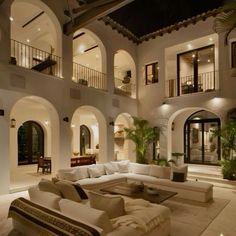 a living room filled with white furniture and lots of windows next to a patio area