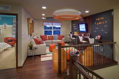 a living room filled with furniture and a chalkboard on the wall above it's stairs