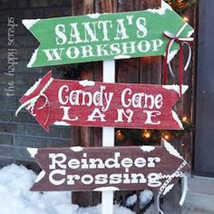 a wooden sign that says santa's workshop, candy cane lane and reindeer crossing