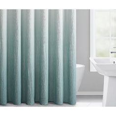 a bathroom with a tub, sink and shower curtain in aqua blue tones on the outside