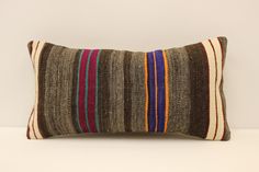 a striped pillow on a white surface