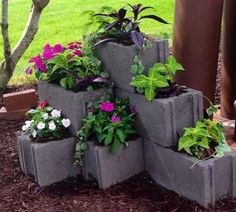 several cement planters are stacked on top of each other in front of a tree