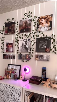 a room with many pictures on the wall and a purple light in front of it