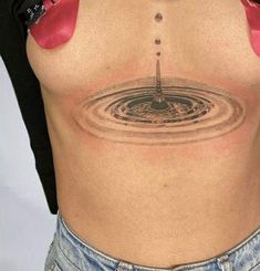 a woman's stomach with a water drop tattoo on her back and bottom part