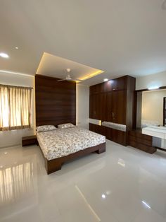 a bedroom with a bed, dressers and mirror in it's center area