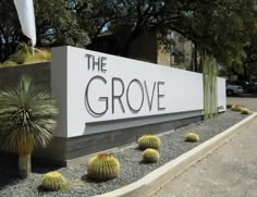 the grove sign in front of some cactus plants