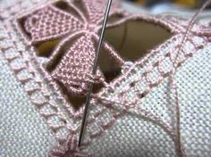 a close up view of a pair of shoes with pink lace on the soles