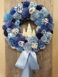 a blue and white wreath hanging on the side of a door