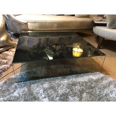 a glass coffee table sitting on top of a rug