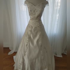 a wedding dress on display in front of a window