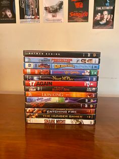 a stack of dvds sitting on top of a wooden table