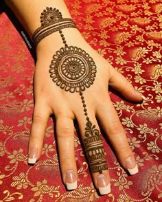 a woman's hand with henna tattoos on it