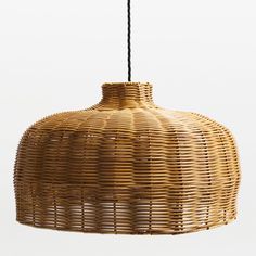 a wicker light hanging from a black cord