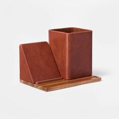 a wooden stand with a brown leather case on it