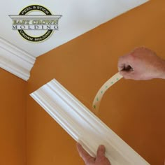 a man is painting the trim on a wall with white paint and green dots around it