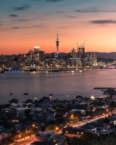 the city skyline is lit up at night, with lights on and buildings in the foreground