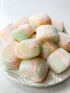 a plate full of powdered donuts on a white tablecloth with green and pink stripes