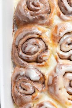 cinnamon rolls in a white casserole dish with icing