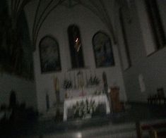 an empty church with stained glass windows and pews