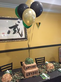 a table topped with balloons and boxes on top of it next to a black table cloth