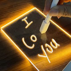 a person is writing on a light up sign