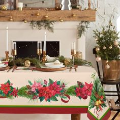 a christmas table with poinsettis and greenery on it, surrounded by candles