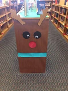 a cardboard box with reindeer's head on it in a book store filled with children's books