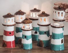 a group of small lighthouses sitting on top of a wooden table next to each other