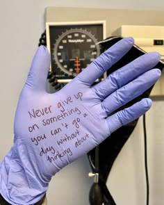 a gloved hand with writing on it in front of a meter