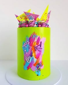 a green canister filled with lots of colorful paper