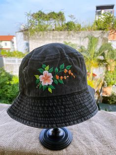 a black hat with flowers on it sitting on top of a table