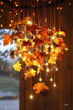 a chandelier made out of leaves with lights hanging from it's sides