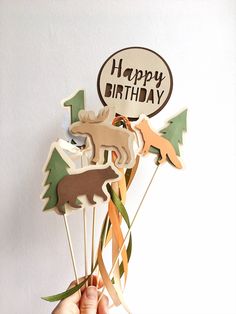 a person holding up a cake topper with animals on it