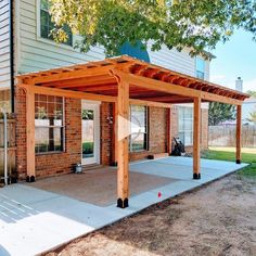 an outdoor covered patio in front of a house