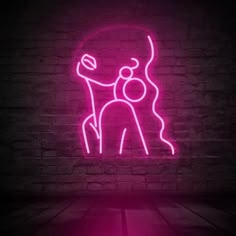 a neon sign that is on the side of a brick wall with a person hugging