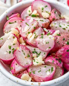 a white bowl filled with sliced up radishes