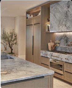 a kitchen with marble counter tops and stainless steel appliances in the middle of the room