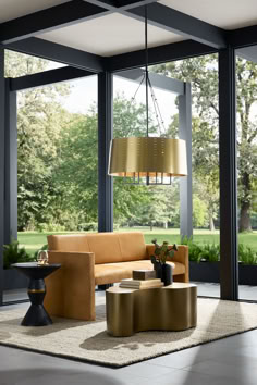 a living room filled with furniture next to large glass windows and trees in the background