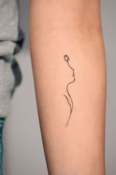 a woman's arm with a single line tattoo on the left side of her leg