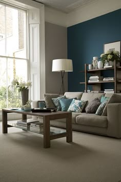 a living room filled with lots of furniture and bookshelves next to a window