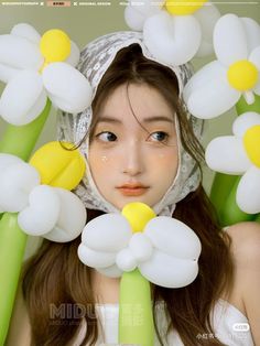 a woman with long brown hair wearing a white dress and yellow flowers on her head