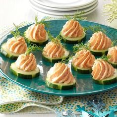 cucumbers with cream cheese and dill are on a plate next to silverware