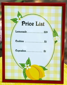 a price list with lemons and flowers on the front, sitting on top of a table