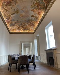 the ceiling in this dining room is painted with an elaborate painting on it's ceiling