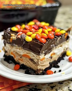 a piece of cake on a plate with candy candies and chocolate chips in the middle