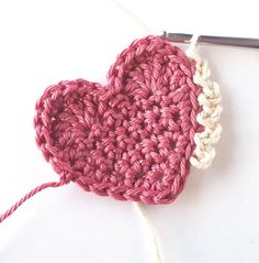 a crocheted heart is being worked on